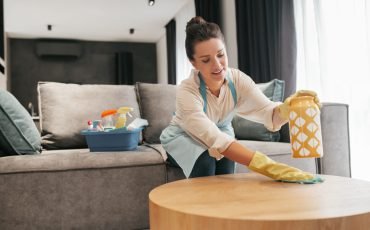 Chores. A woman cleaning a table surfcase with disinfector