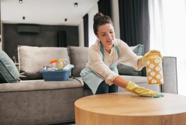Chores. A woman cleaning a table surfcase with disinfector