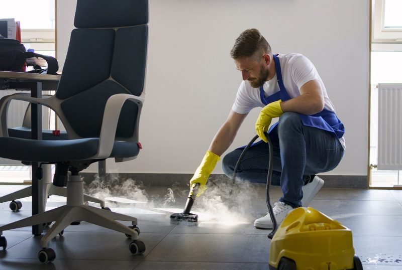 professional-cleaning-service-person-using-steam-cleaner-office